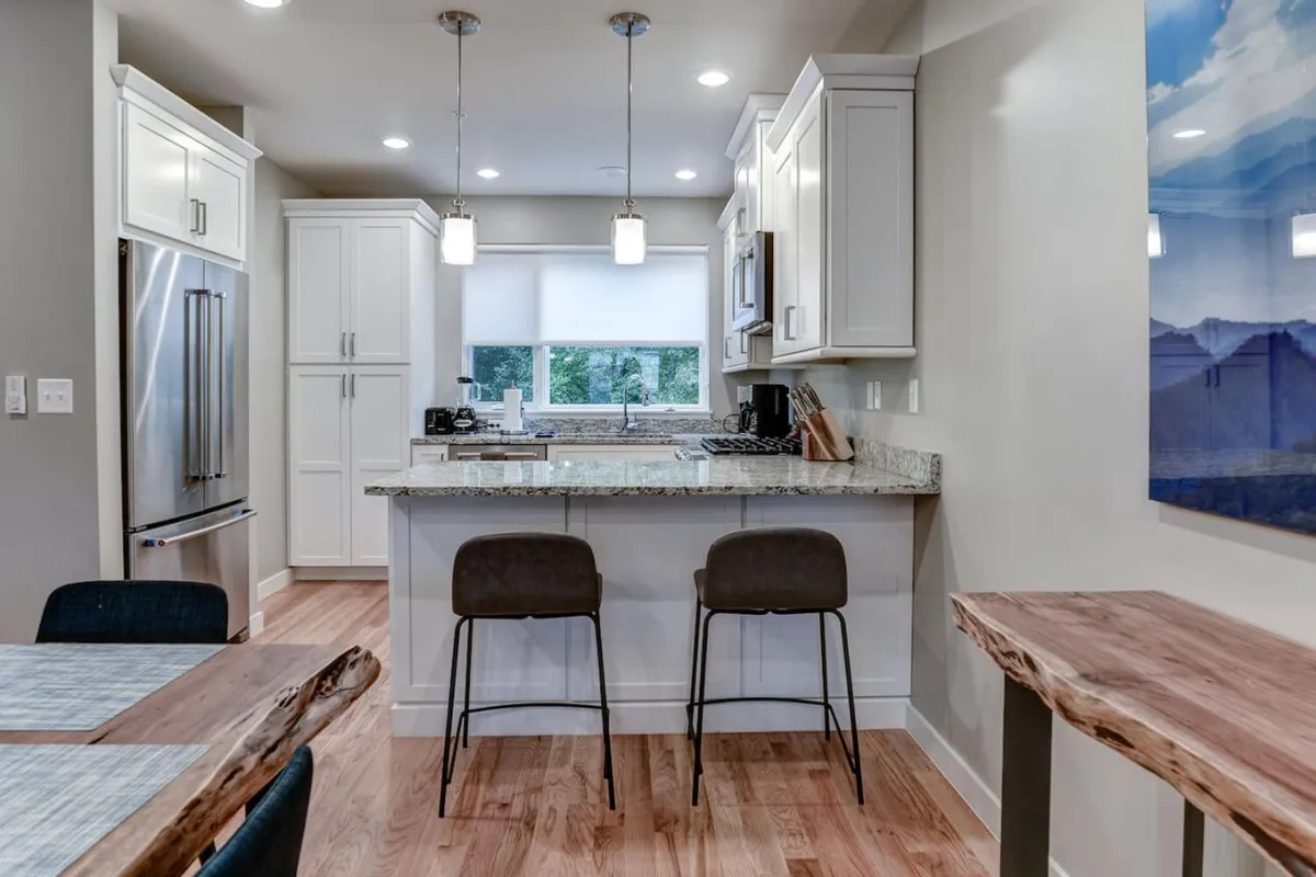 A modern kitchen with a central island, granite countertops, stainless steel appliances, and an abundance of natural light. The layout encourages conversation and culinary creativity, embodying the heart of the home.
